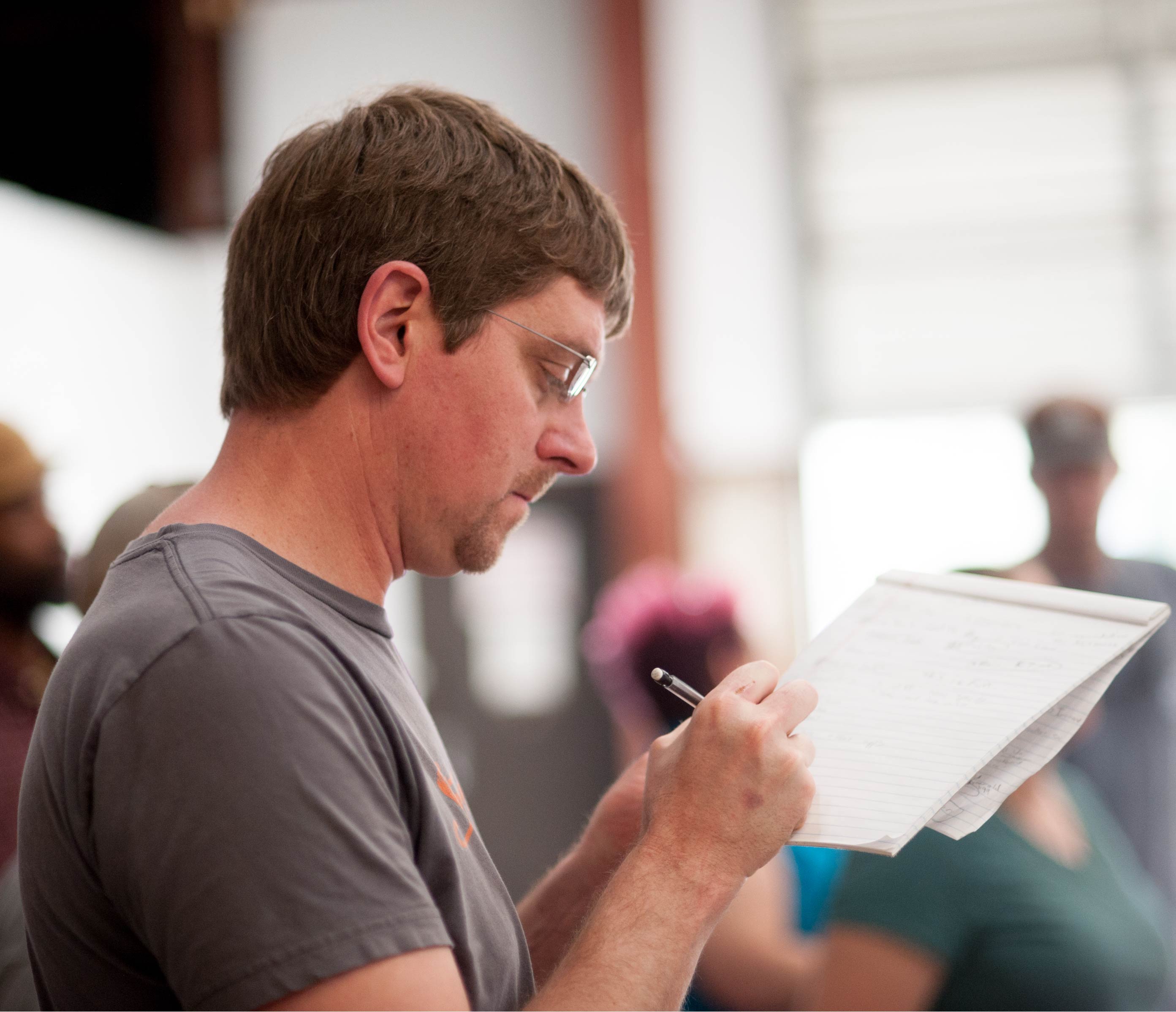 Image of man writing on notepad