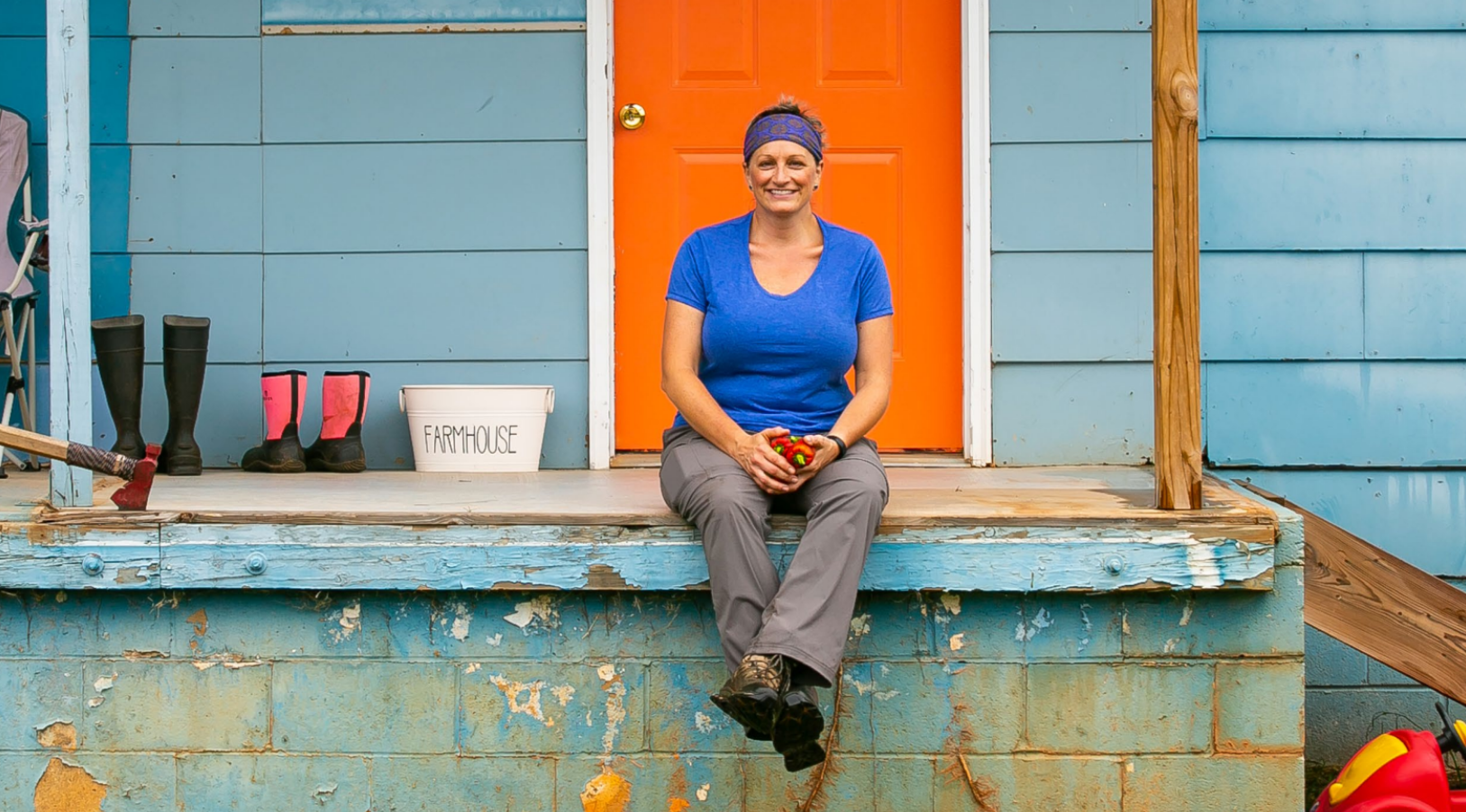 Woman sitting in front of farmhouse 