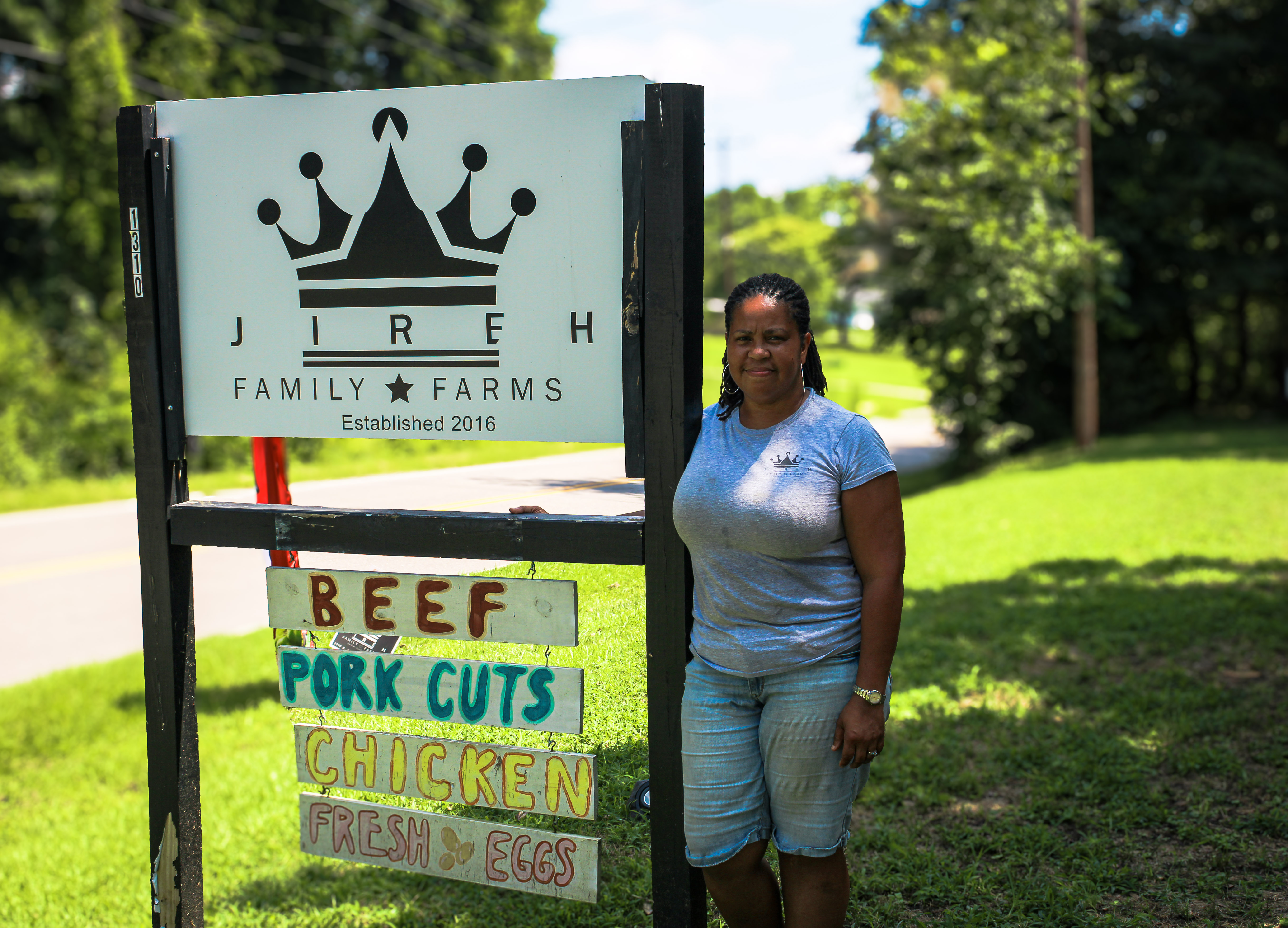 Valerie Jarvis standing with the Jireh Family Farms sign